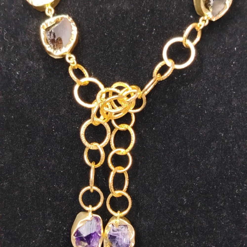 Gold necklace with gemstone pendants on a black background