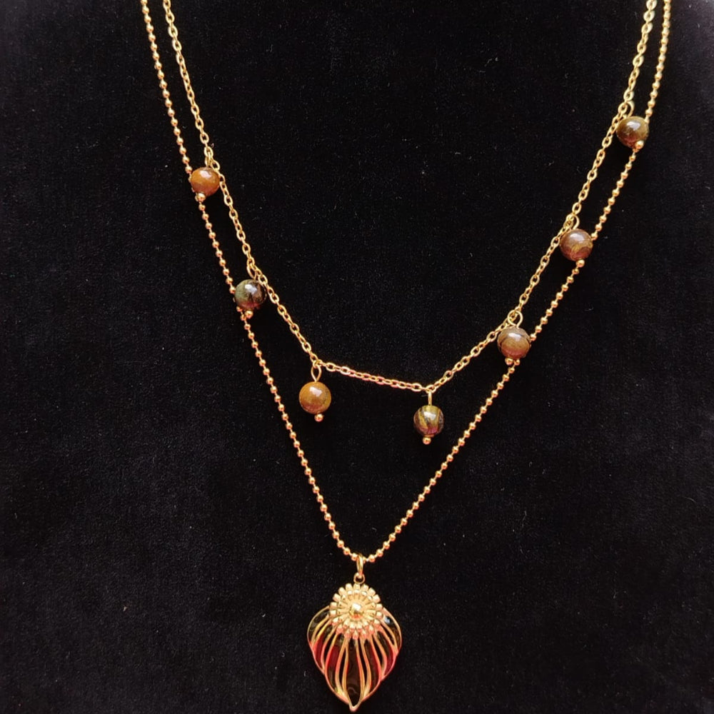 Gold necklace with beads on a black mannequin