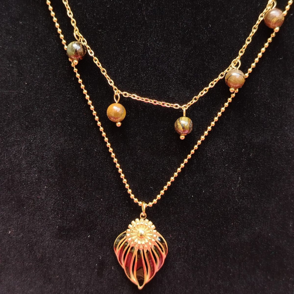 Gold necklace with a heart-shaped pendant on a black background