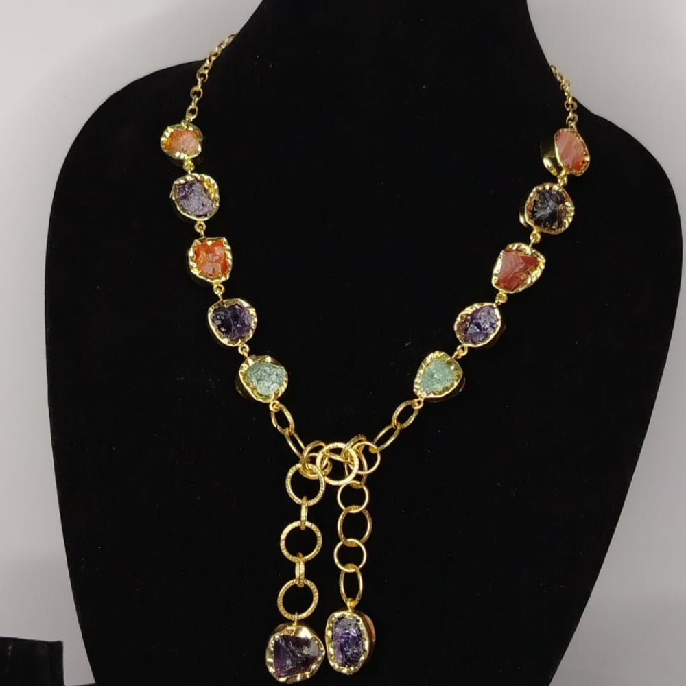 Necklace with multicolored gemstones on a black mannequin bust against a gray background