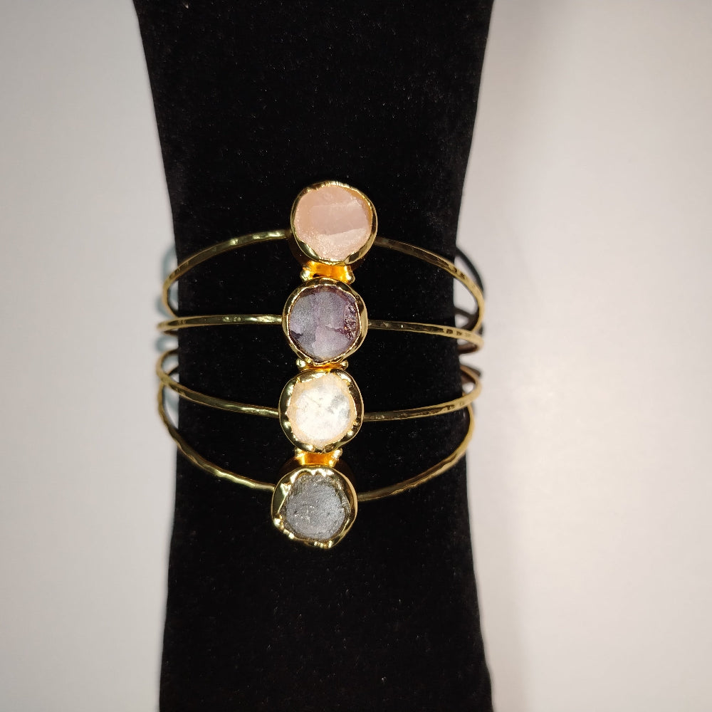18K Gold Plated Bracelet with round, faceted Gemstones on a Black Stand