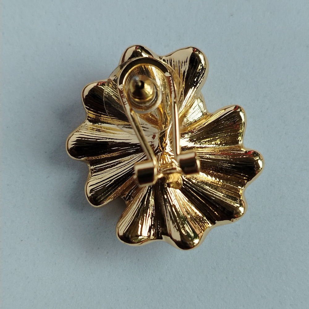 Latch Back Closure of a Golden Flower Earrings on a Gray Surface