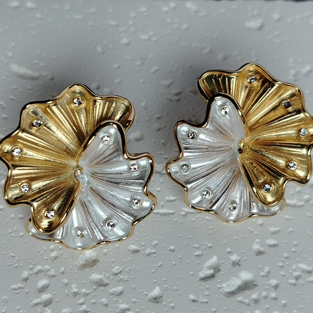 Pair of Gold and Silver Korean Flower Earrings on textured White Background