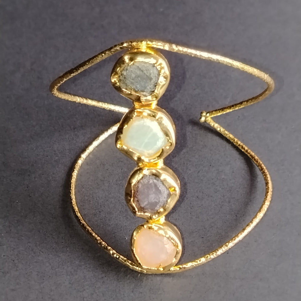 Golden Bracelet with Four Gemstones on a Gray Background