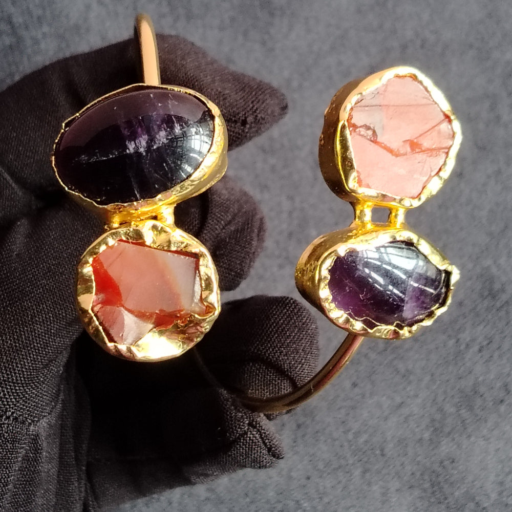 Sleek Golden Bracelet with Carnelian and Amethyst on Either End Held by Hand in Black Gloves