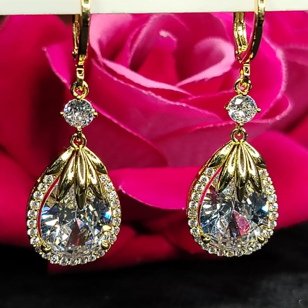 Golden American Diamond Teardrop Earrings on Hoops against a Pink Rose Background
