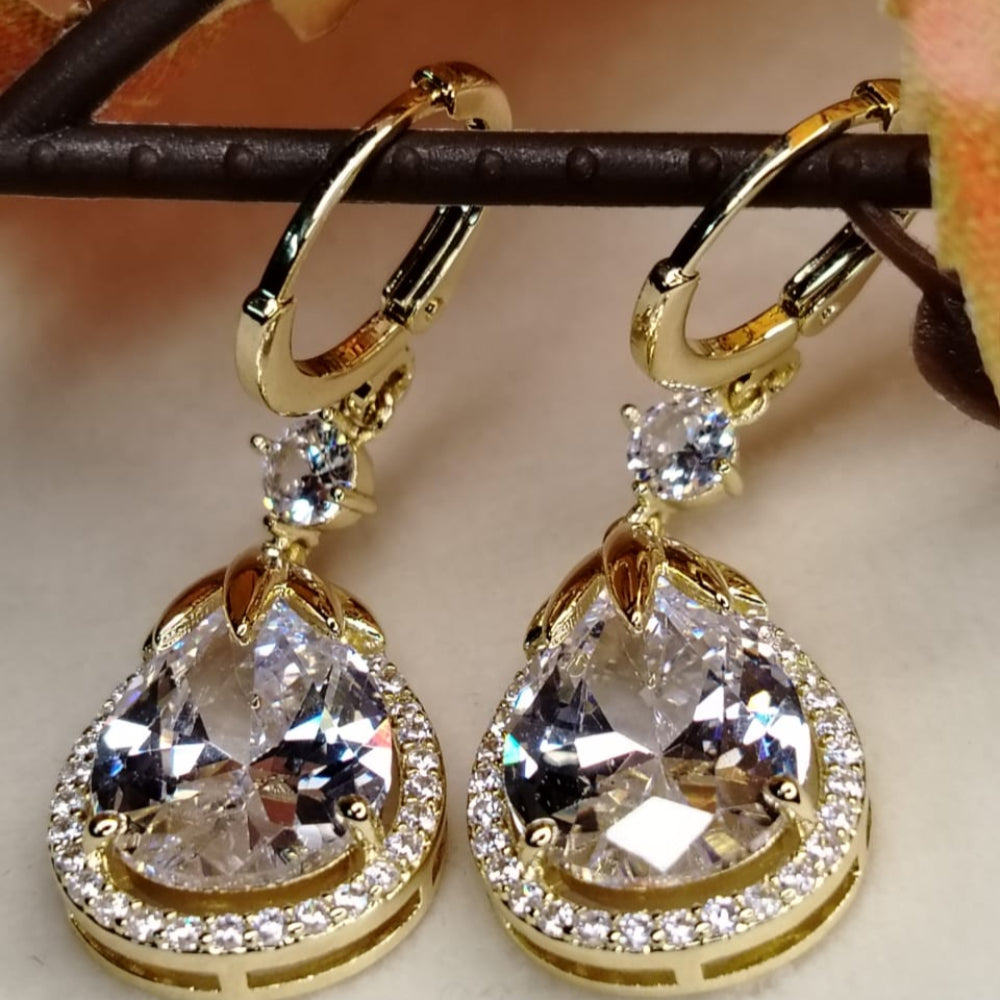 Golden Hoops with American Diamond Tear Drops on a Beige Background