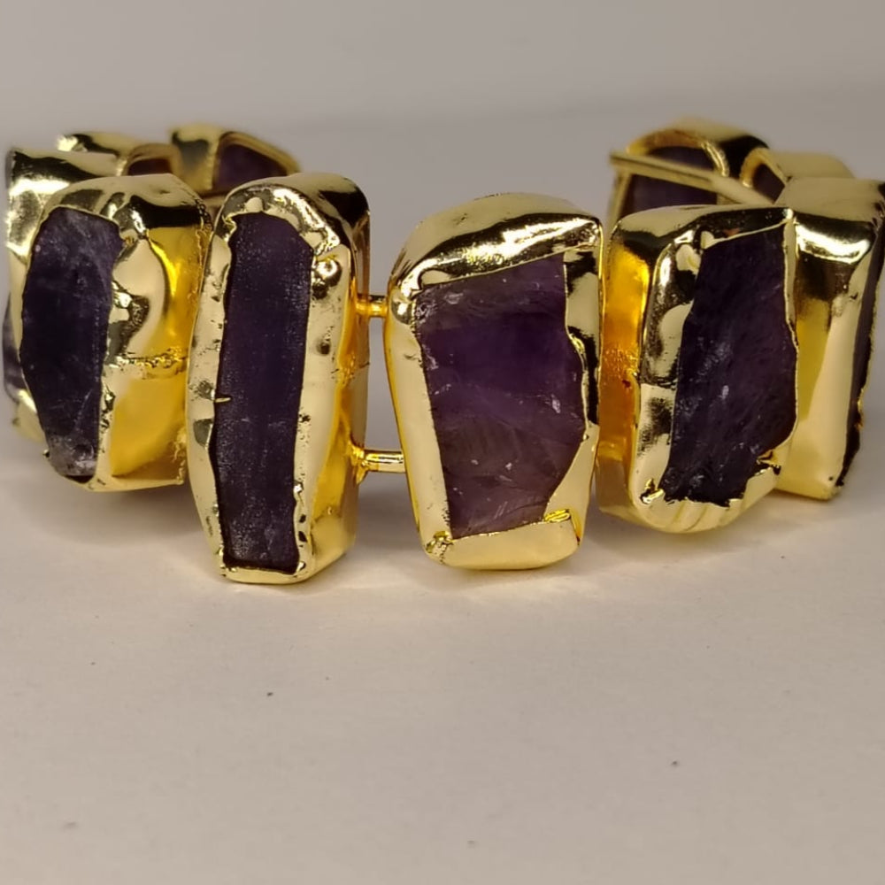 Gold-rimmed Amethyst Handcuff on Beige Surface