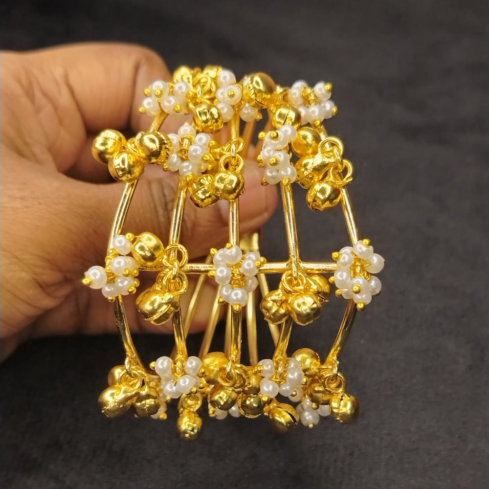 Multilayered Gold And Pearl Beaded Bracelet Held by a Hand on Black Background