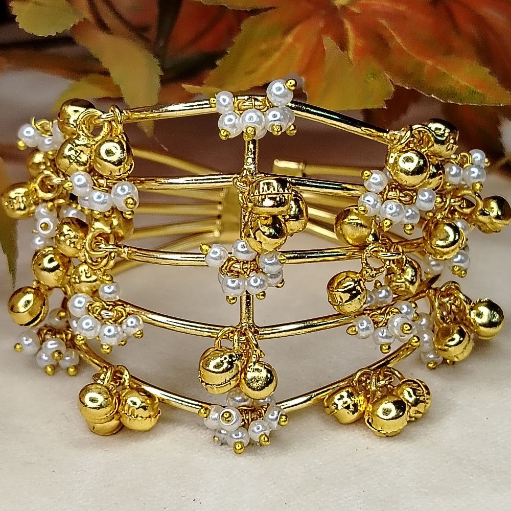 Golden Bracelet with Golden and Hand-worked Pearl Beads on a Beige Surface with Autumn Leaves