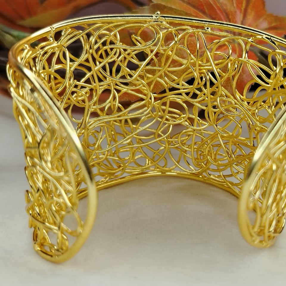 Broad Golden Filigree Open Handcuff on White background with Autumn Leaves
