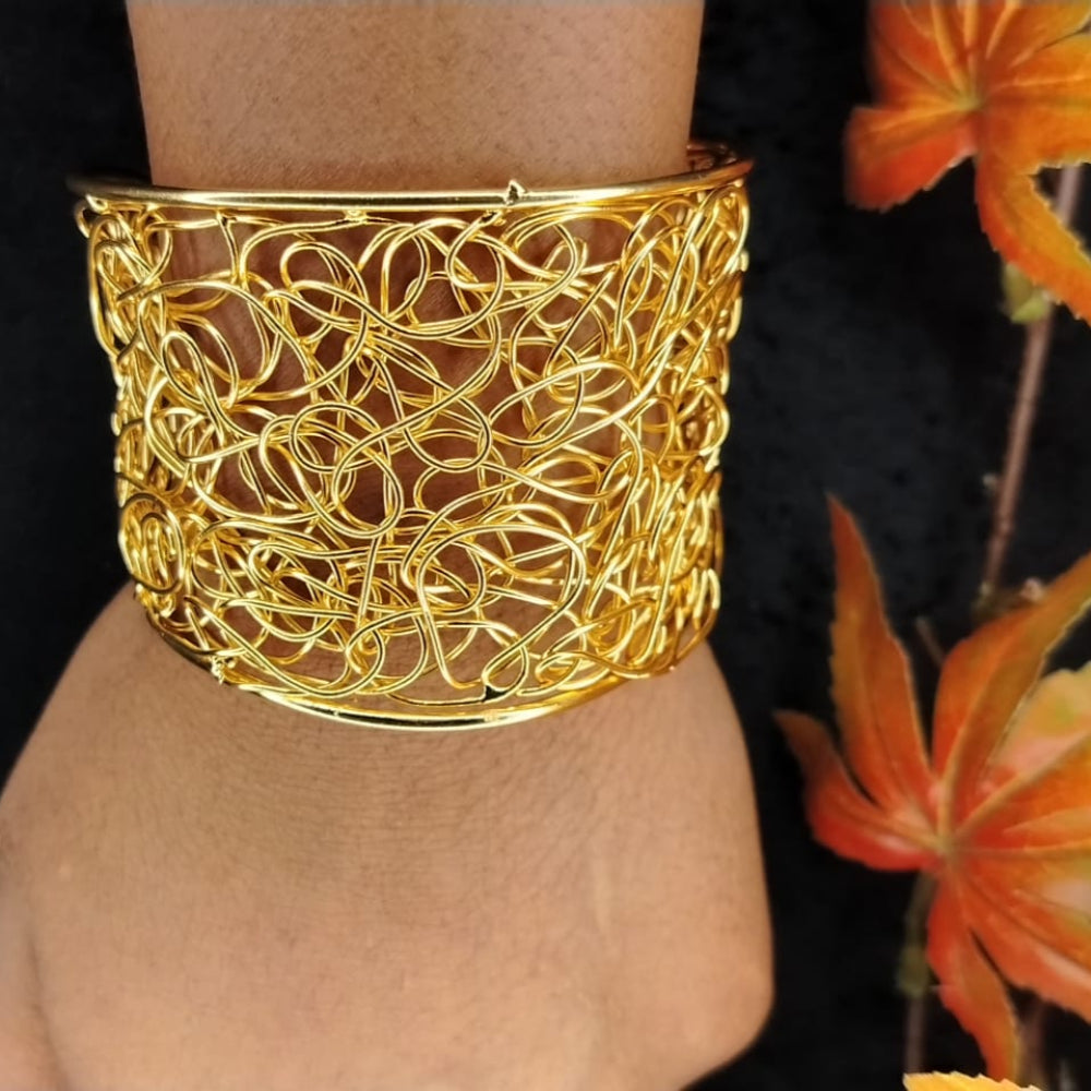 Broad Golden Filigree Handcuff on a Wrist with Back Background and Autumn Leaves