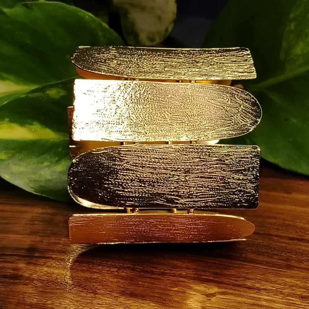 Golden Textured Broad Handcuff on a Wooden Surface