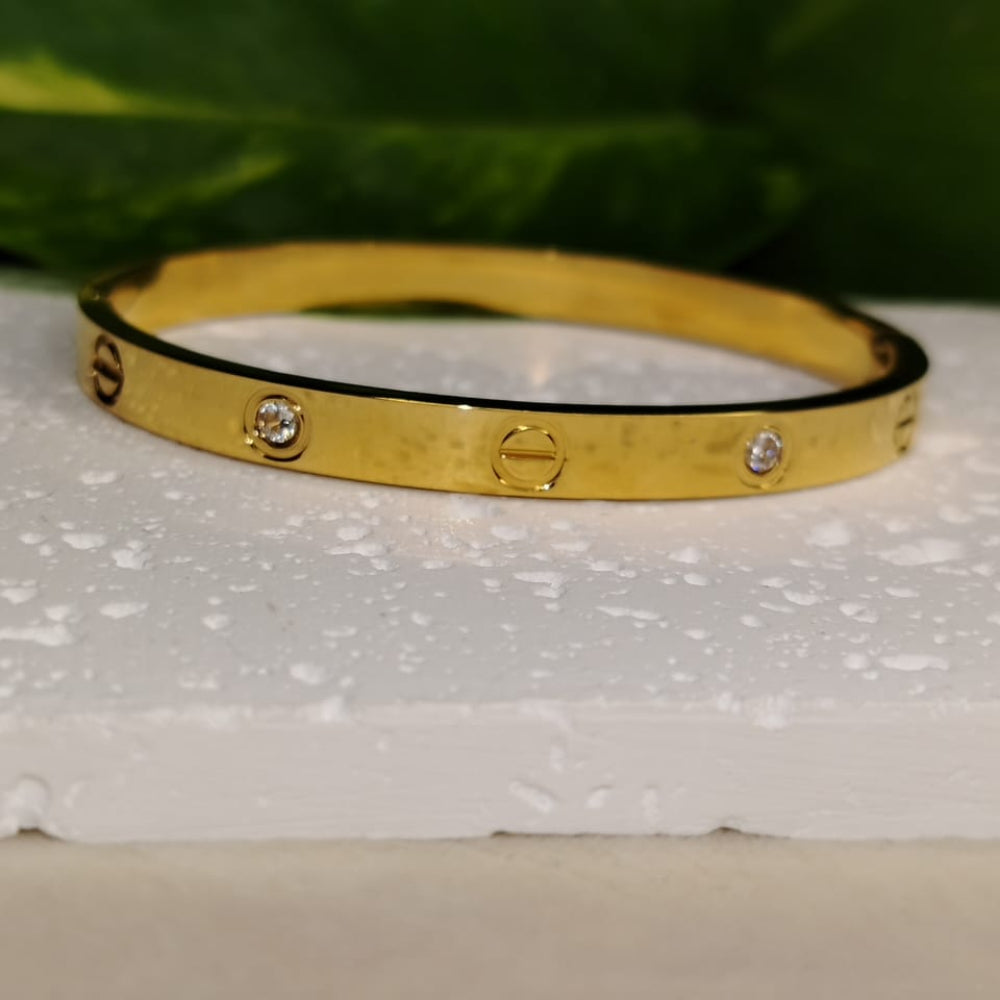 Minimalist Golden Bracelet with Diamond Accents on a White Surface