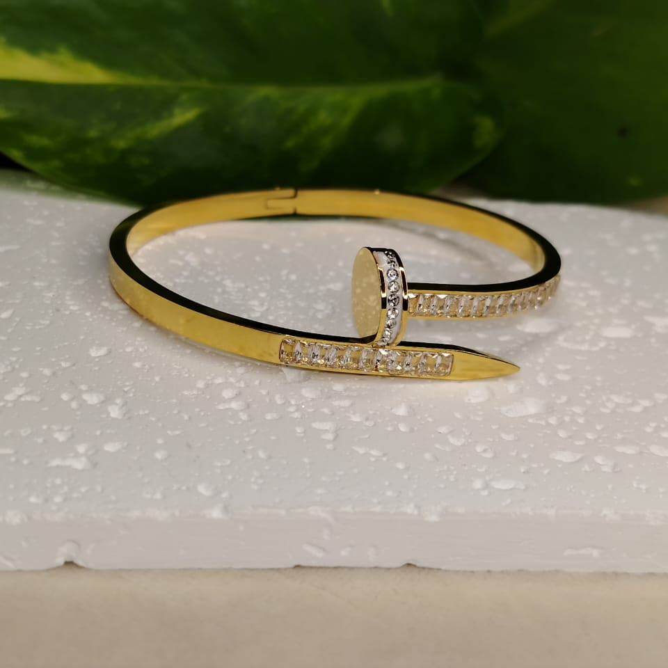 Golden Bracelet with Bracket Setting American Diamonds n a White Textured Background