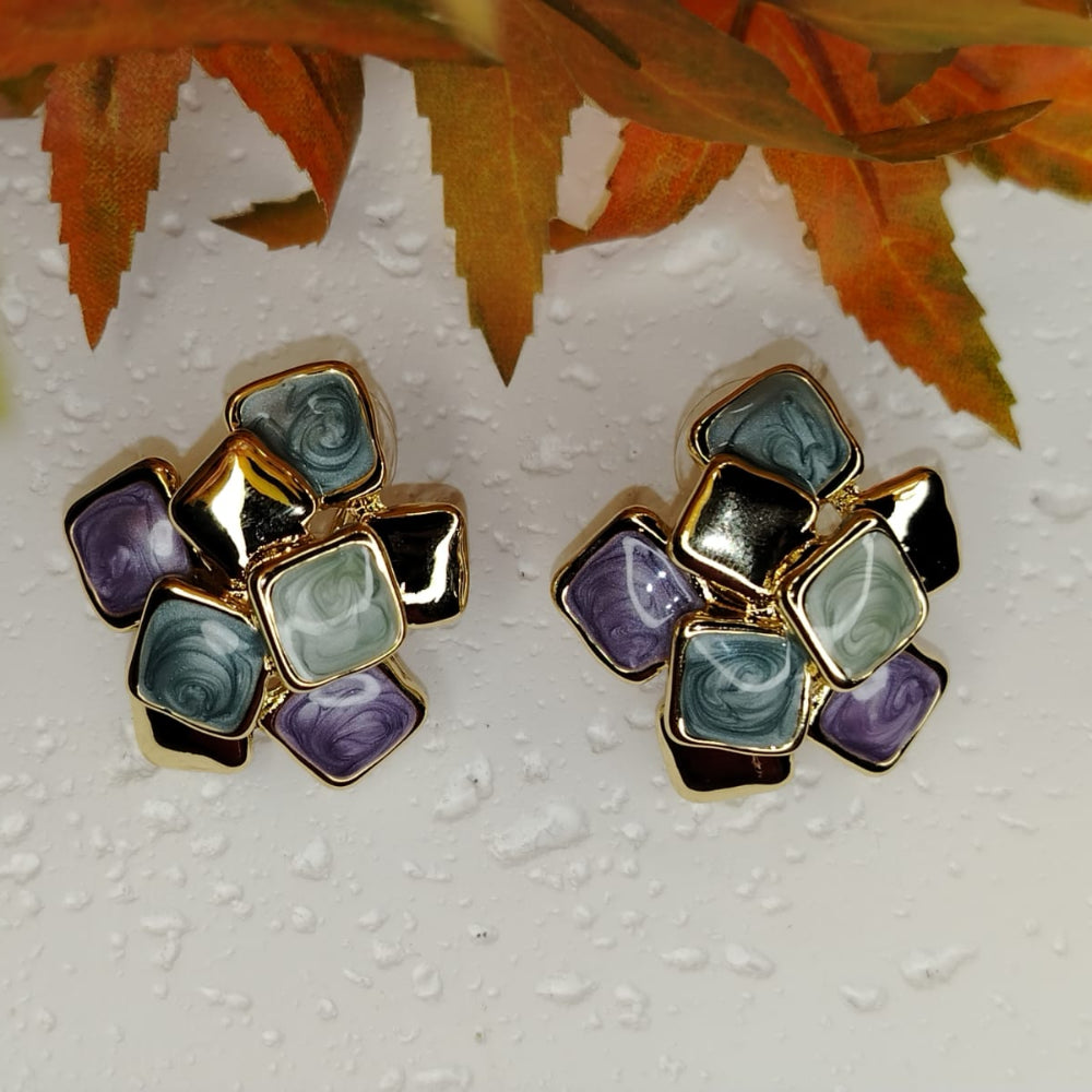 Pair of Geometric Earrings with Multicolored Enamel on Textured hite Background and Autumn Leaves