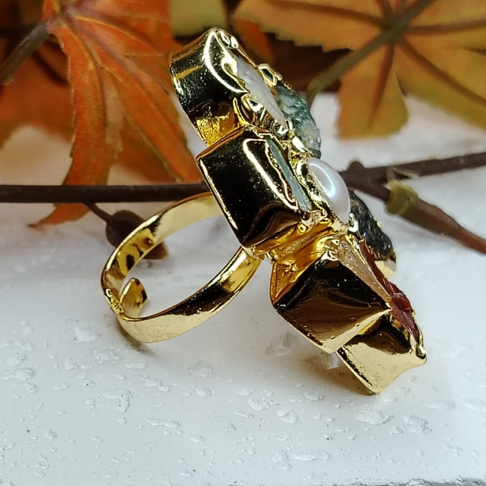 Side View of Natural Stones Ring with Pearl on a White Surface