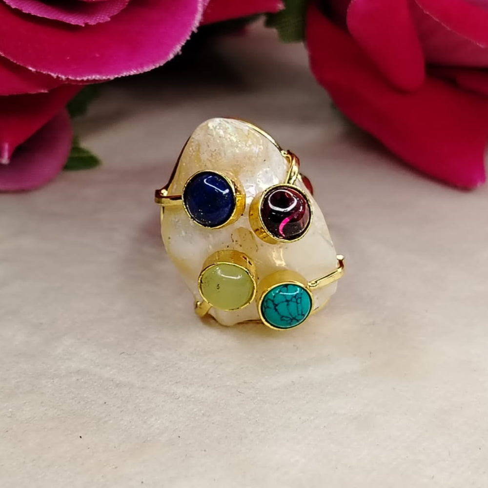 Golden Pearl Ring with Natural Stones on Beige Surface against Roses