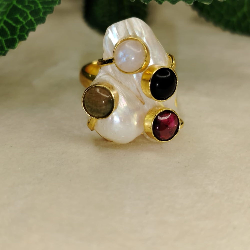 Golden Pearl RIng with Four Multicolored Natural Stones Embedded on Beige Surface