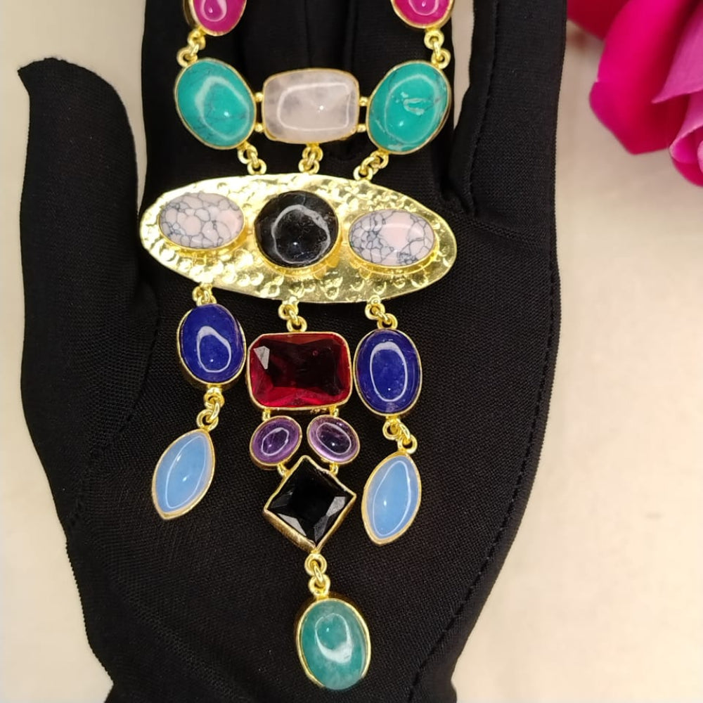 Colorful Necklace with Semi-precious Stones held by a Black-gloved Hand against a Pink Flower Background