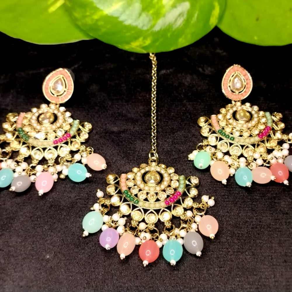 Pair of Multicolor Earrings and a Maati with Kundan on Black Surface