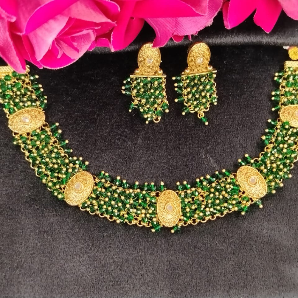 Golden Green Handworked Hydro Bead Necklace and Earrings against Roses