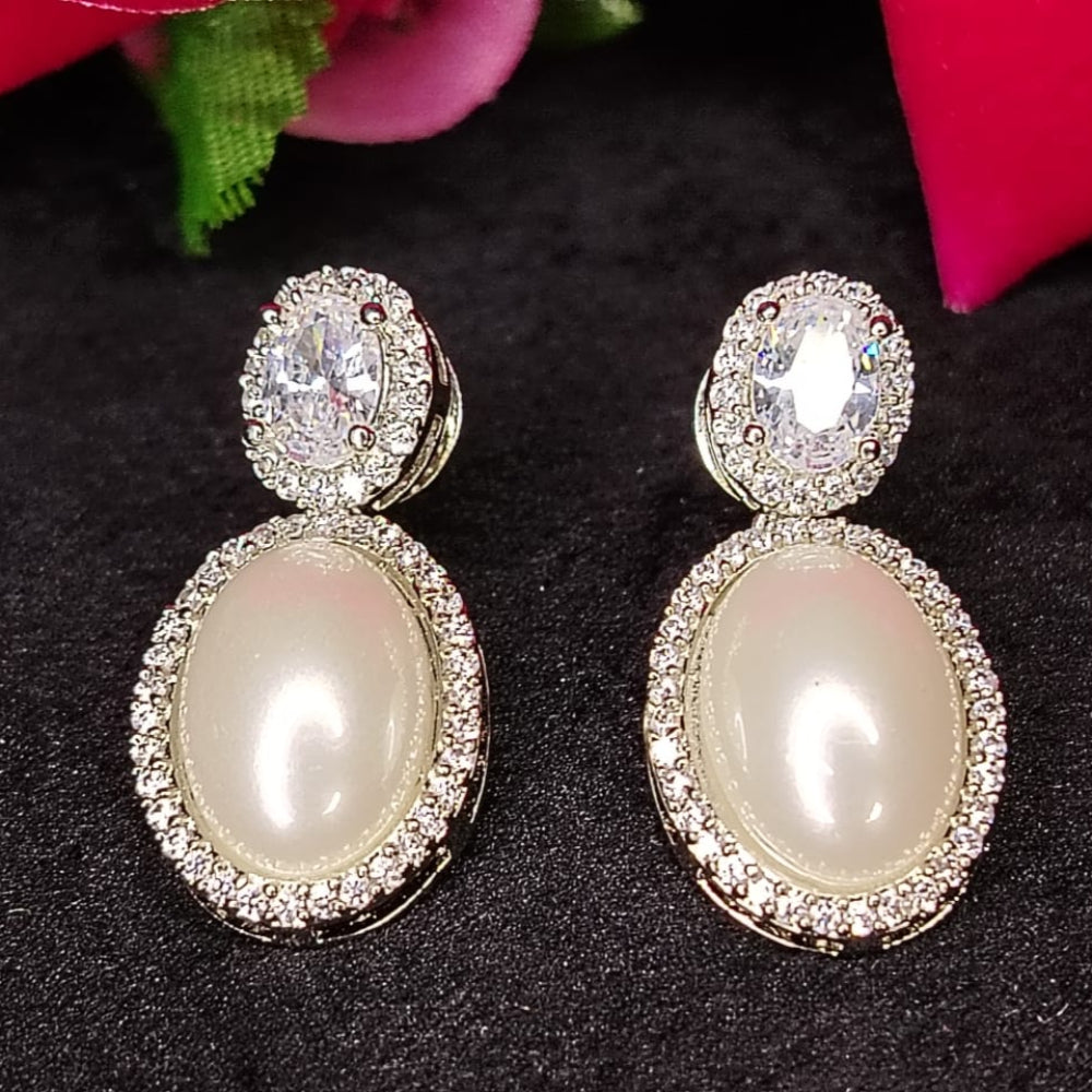 Silver Polished Pearl Earrings with Diamond Accents on Black Surface