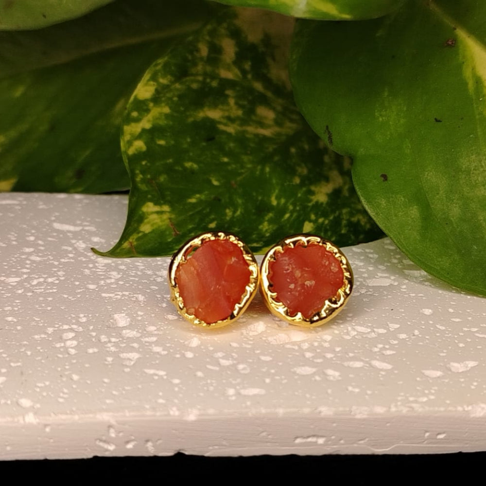 Natural Red Stone Earrings with Golden border on a Textured Wite Surface