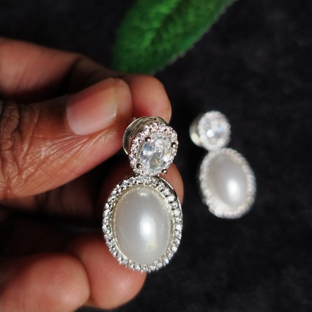American Diamond Pearl Earrings Held in Hands against Blur Background