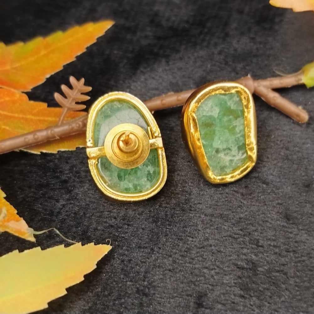 Back View of Gold and green earrings on a dark surface with autumn leaves