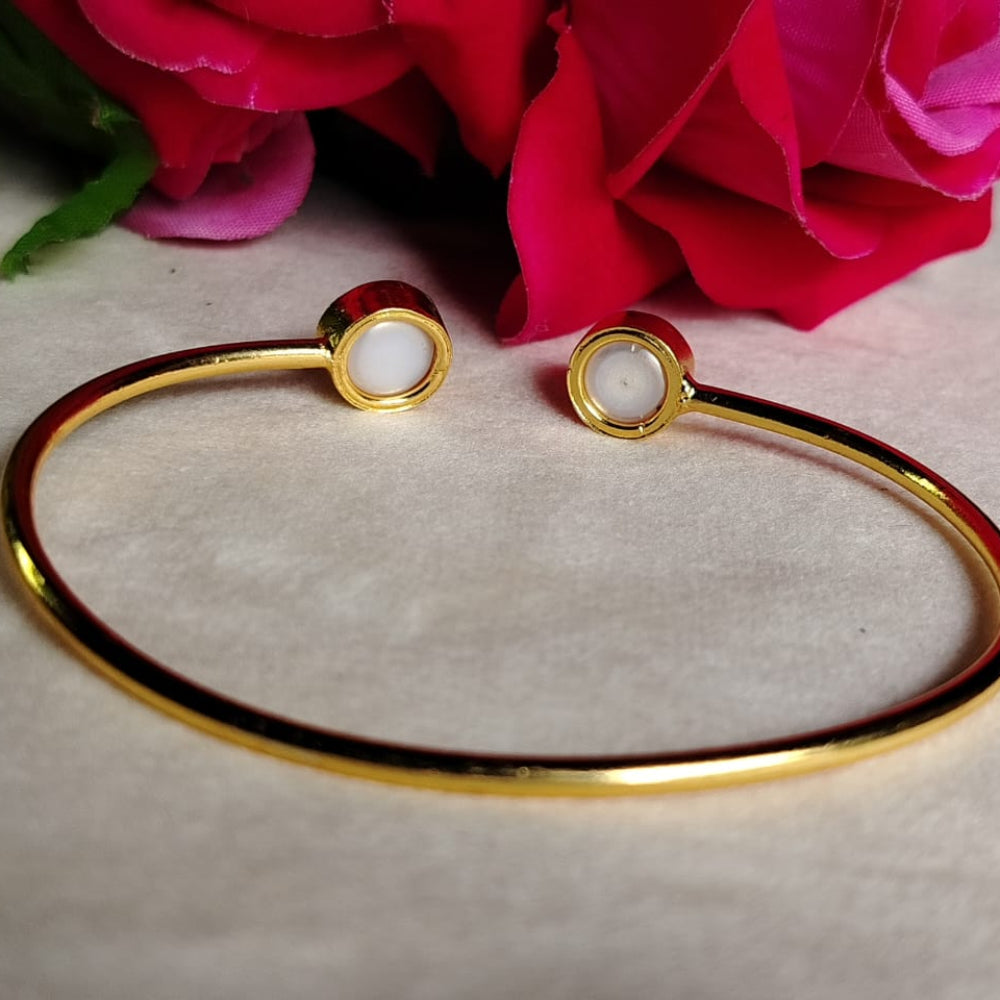 Golden bracelet with Natural Pearls on a light background with pink flowers.