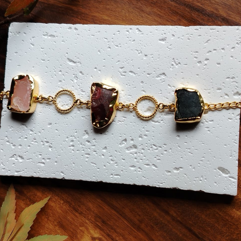 Bracelet with gold chain and Natural Stones on a textured white Stone