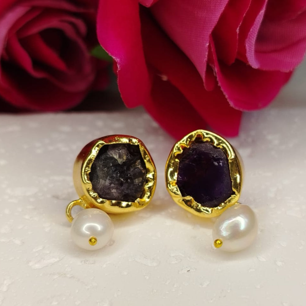 Golden earrings with Amethyst and pearls in front of red roses
