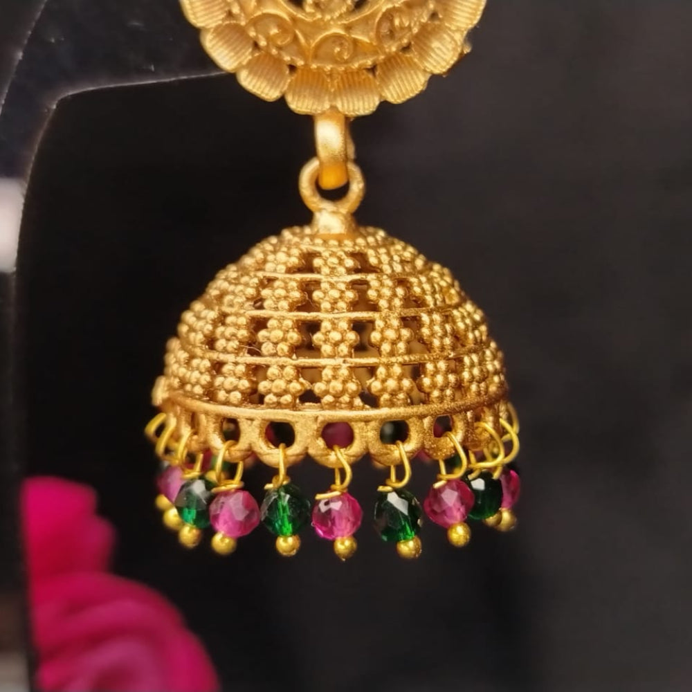 Golden jhumka earring with colorful beads against a dark background