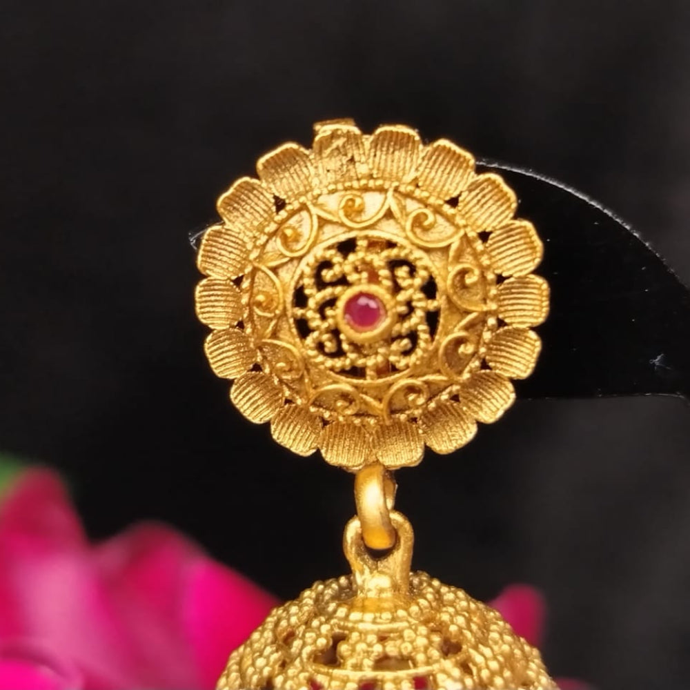 Golden Sud of Jhumka with intricate design against a black background