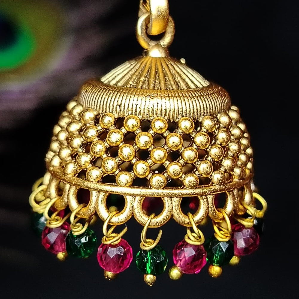 Golden jhumka with colorful gemstones on a dark background