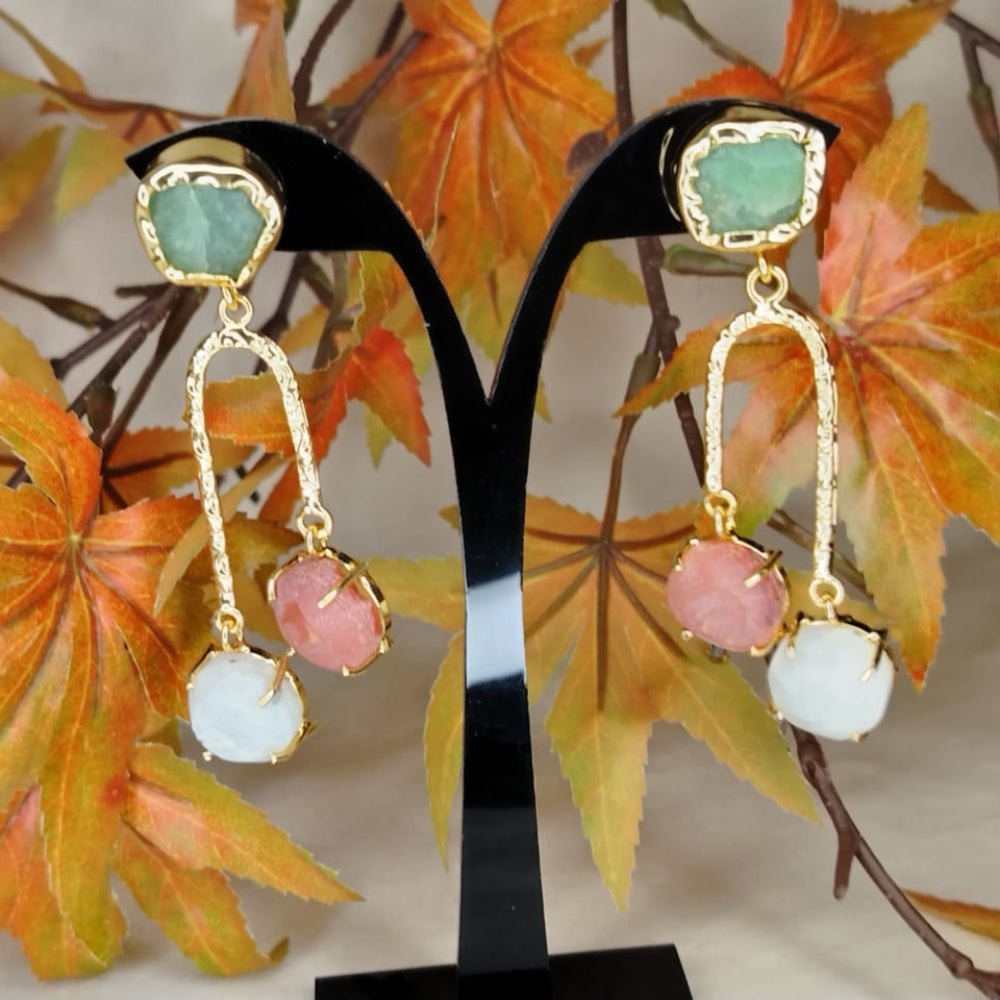Colorful earrings on a stand with autumn leaves in the background