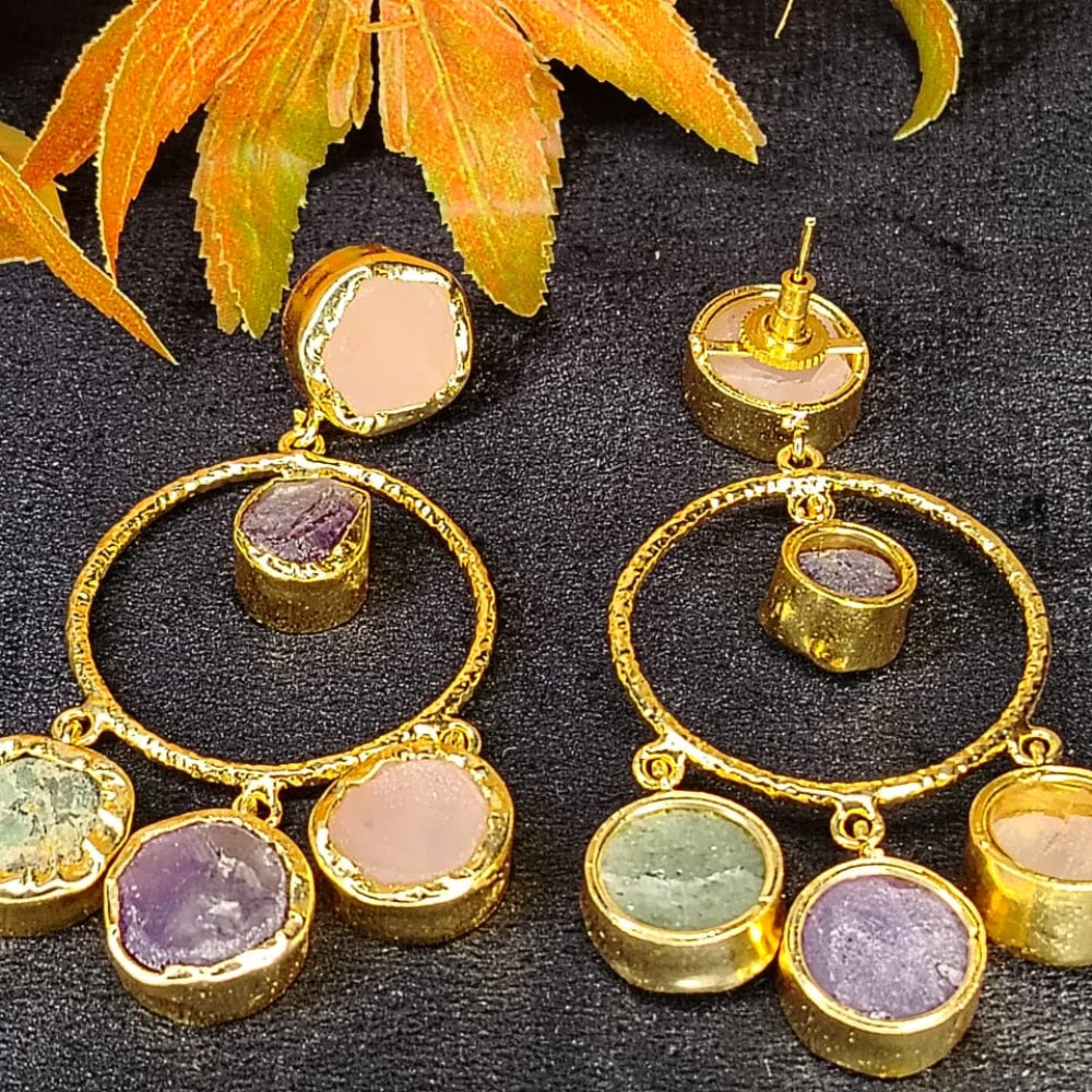 Back View of Gold hoop earrings with gemstone drops on a dark surface with leaves.