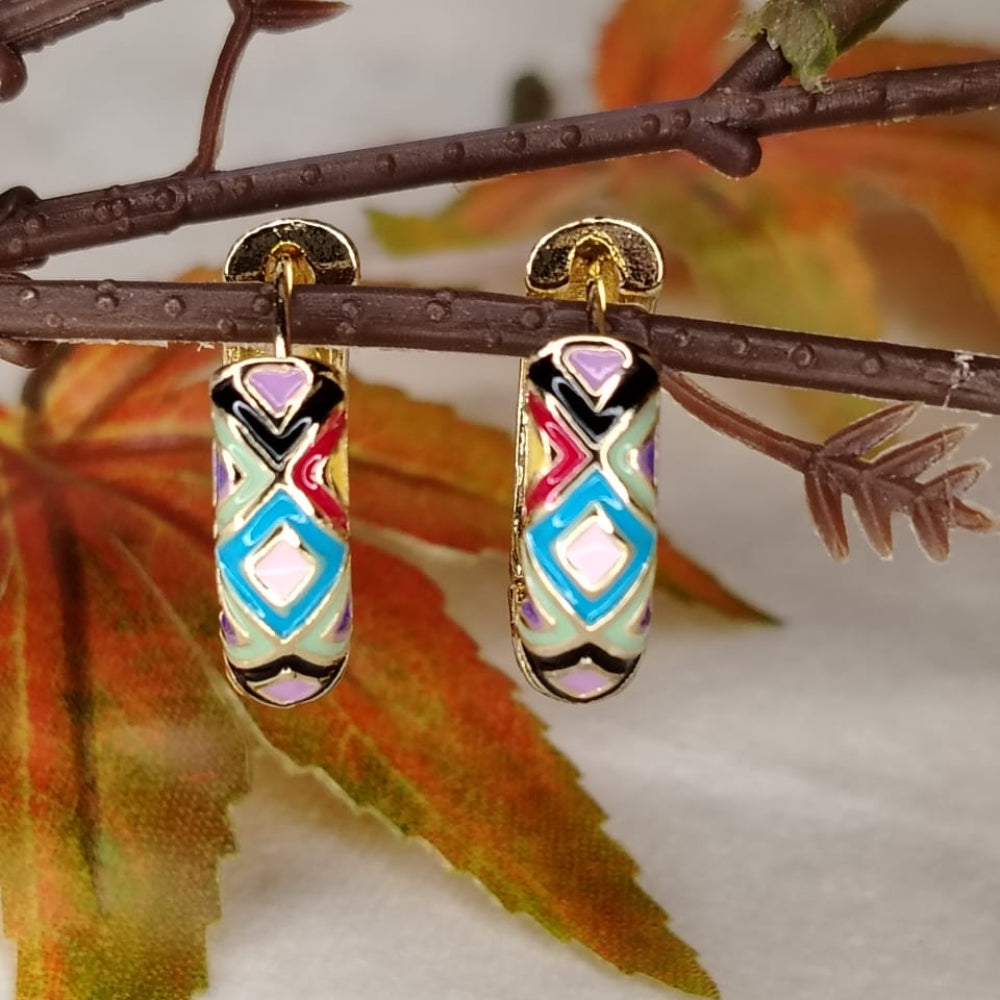 Colorful Enamel earrings with gold accents on a branch with leaves