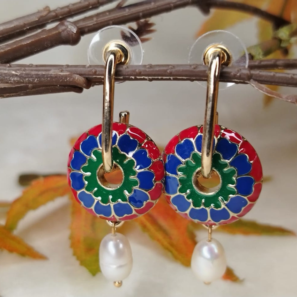 Colorful circular earrings with pearl drops on a branch background