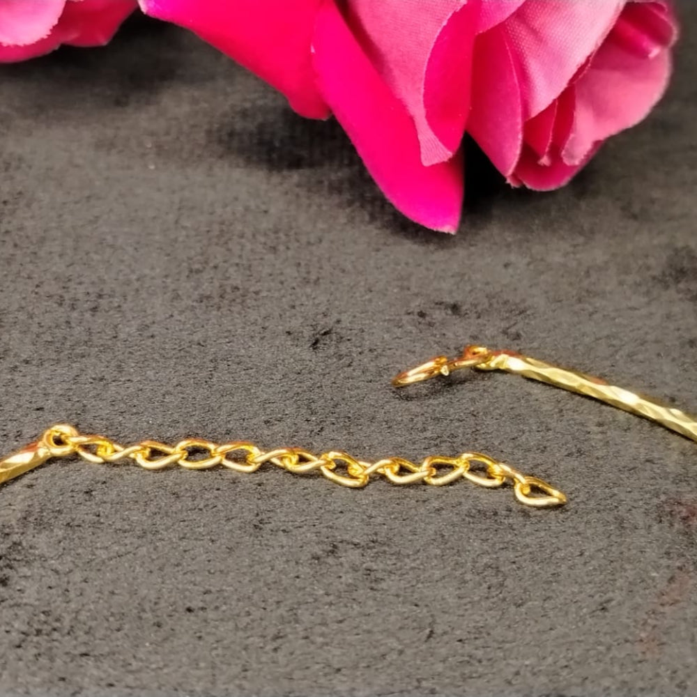 Gold chain necklace with Hook Closure on a dark surface with pink flowers in the corner