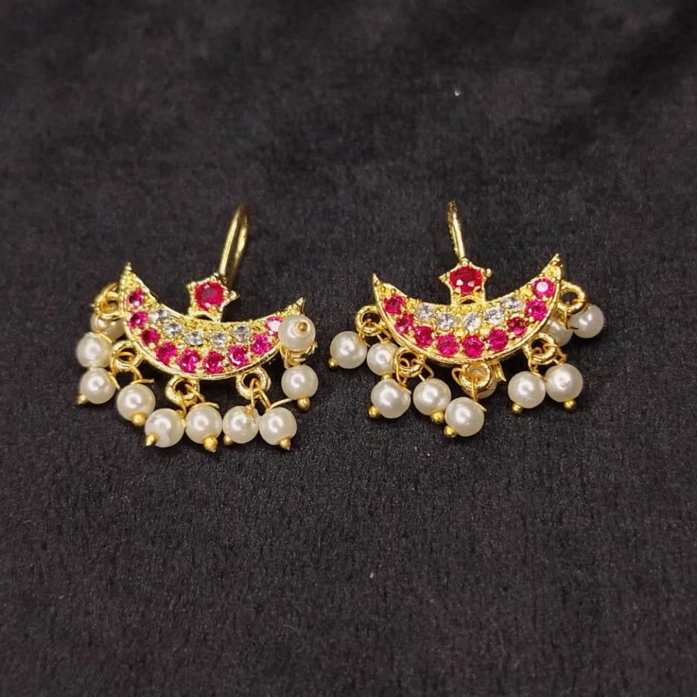 Pair of gold earrings with pearls and red stones on a black background