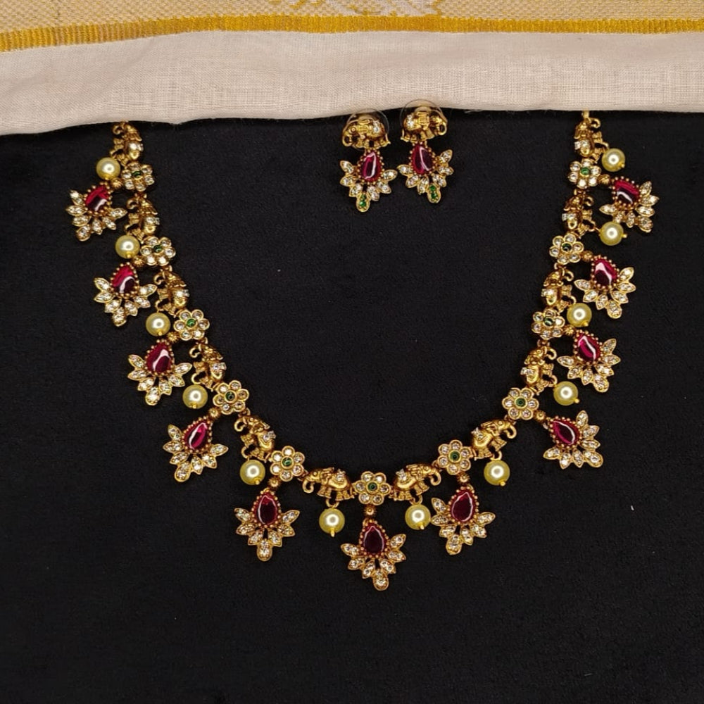 Gold necklace with red gemstones on a black background