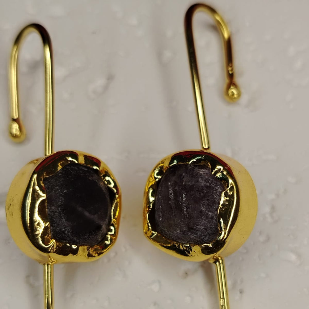 Gold bugadi with dark Amethyst on a textured beige background