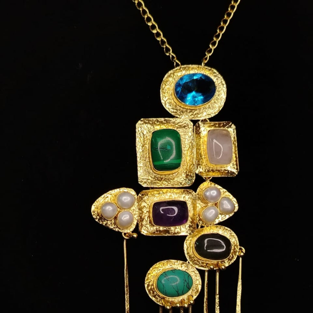 Gold necklace with multicolored gemstones on a black background