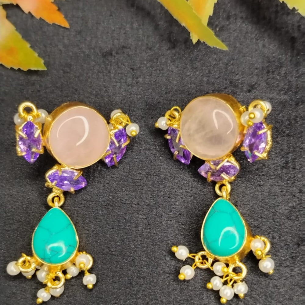 Pair of gold earrings with gemstones on a dark background