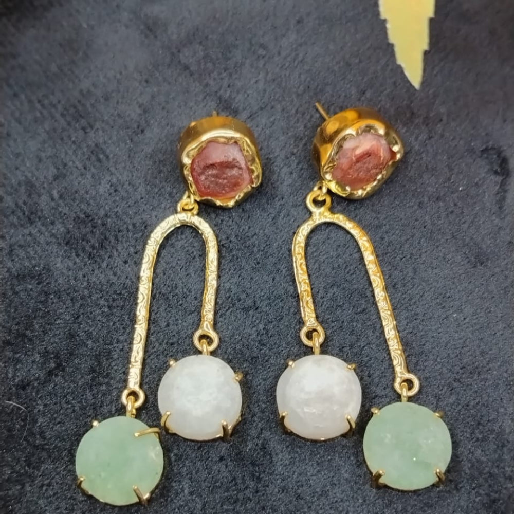 Pair of gold earrings with round gemstones on a dark background