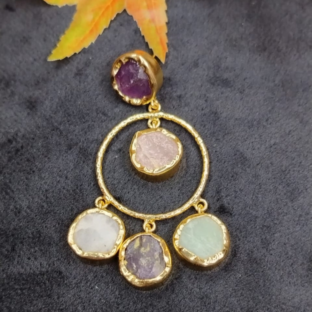 Golden Earrings with gemstones in Hoops on a black Surface