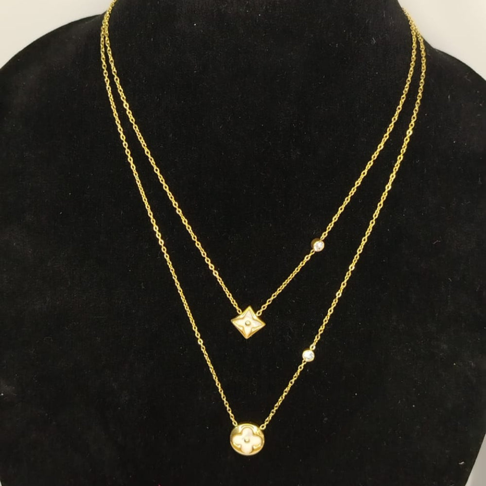 Two-layered gold necklaces on a black mannequin bust.