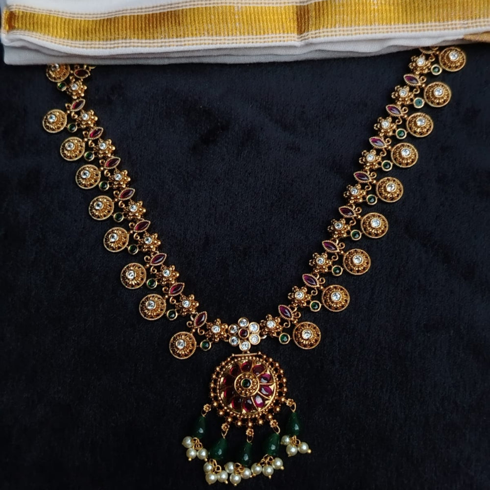 Ornate jewelry piece with gold and gemstones on a dark background